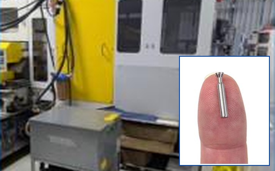 High-tolerance grinding cell at Soaris, with a finished ground component shown at scale on a fingertip